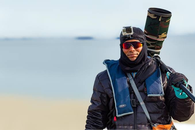 Founder in wilderness gear with camera